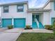 Two-story condo building with teal garage doors and accents at 6629 Pineview Ter # 5-201, Bradenton, FL 34203