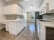 Modern kitchen with white cabinets and tile flooring at 6629 Pineview Ter # 5-201, Bradenton, FL 34203