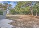 Large backyard with mature trees and a grassy area at 11615 Meadow Dr, Port Richey, FL 34668