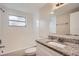 Bathroom with granite countertop, bathtub, and updated vanity at 11615 Meadow Dr, Port Richey, FL 34668