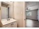 Small bathroom with vanity and mirror, adjacent to bedroom at 11615 Meadow Dr, Port Richey, FL 34668