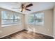 Bright bedroom with ceiling fan and wood-look floors at 11615 Meadow Dr, Port Richey, FL 34668