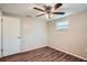 Simple bedroom with ceiling fan, wood-look floors, and window at 11615 Meadow Dr, Port Richey, FL 34668