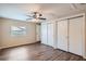 Bright bedroom with ceiling fan, wood-look floors, and double closets at 11615 Meadow Dr, Port Richey, FL 34668