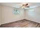 Spacious bedroom with ceiling fan and wood-look flooring at 11615 Meadow Dr, Port Richey, FL 34668