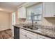 Updated kitchen with white cabinets and granite countertops at 11615 Meadow Dr, Port Richey, FL 34668
