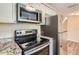 Renovated kitchen with stainless steel appliances and granite countertops at 11615 Meadow Dr, Port Richey, FL 34668