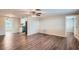 Open living room with wood-look floors and kitchen peek at 11615 Meadow Dr, Port Richey, FL 34668