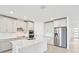 Modern kitchen with an island, stainless steel appliances, and stylish gray cabinets at 13847 Richland Gulf Cir, Parrish, FL 34219