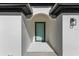 Modern front entrance with light teal door and arched entryway at 1649 N San Mateo Dr, North Port, FL 34288