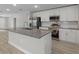 Modern kitchen with white cabinets, granite island and stainless steel appliances at 1649 N San Mateo Dr, North Port, FL 34288