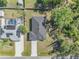 Bird's eye view of a well-maintained property with a dark roof, green lawn, and long driveway at 4495 Eldron Ave, North Port, FL 34286