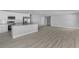Open-concept living area with wood-look flooring connecting the kitchen and living spaces at 4495 Eldron Ave, North Port, FL 34286