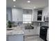 Modern kitchen with white cabinets, marble countertops, and a farmhouse sink at 5519 Turtle Crossing Loop, Tampa, FL 33625