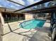 Inviting kidney-shaped pool with screened enclosure at 12010 Villa Rd, Spring Hill, FL 34609