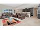 Open living room with leather furniture, and kitchen view at 33161 Kateland Dr, Wesley Chapel, FL 33545