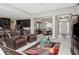 Open living room features leather furniture, a glass coffee table, and a view into the kitchen at 33161 Kateland Dr, Wesley Chapel, FL 33545