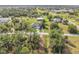Pastoral view of a new home with a gray roof, lush green lawn and driveway in a verdant neighborhood at 16760 Acapulco Rd, Punta Gorda, FL 33955