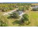 Drone view of new home in a wooded area with a dark metal roof at 16760 Acapulco Rd, Punta Gorda, FL 33955