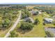 Aerial view of a house on a large, grassy lot with many trees and a street nearby at 16760 Acapulco Rd, Punta Gorda, FL 33955