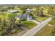 Beautifully landscaped property with a modern white home, dark roof, and extended driveway at 16760 Acapulco Rd, Punta Gorda, FL 33955