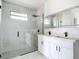 Modern bathroom featuring a glass-enclosed shower and double vanity with sleek fixtures and bright lighting at 16760 Acapulco Rd, Punta Gorda, FL 33955