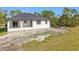 Exterior view of home highlighting architectural style, metal roof, and well-maintained landscaping at 16760 Acapulco Rd, Punta Gorda, FL 33955