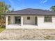 Rear elevation of a single-story house featuring a metal roof and a stucco exterior at 16760 Acapulco Rd, Punta Gorda, FL 33955