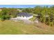 New construction home with modern white stucco and metal roof surrounded by green grass at 16760 Acapulco Rd, Punta Gorda, FL 33955