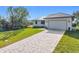 Charming single-story home with well-manicured lawn, grey metal roof and paver driveway at 16760 Acapulco Rd, Punta Gorda, FL 33955