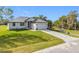Charming single-story home with well-manicured lawn, grey metal roof and paver driveway at 16760 Acapulco Rd, Punta Gorda, FL 33955