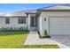 Charming single-story home with well-manicured lawn, grey metal roof and paver driveway at 16760 Acapulco Rd, Punta Gorda, FL 33955