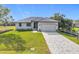 Charming single-story home with well-manicured lawn, grey metal roof and paver driveway at 16760 Acapulco Rd, Punta Gorda, FL 33955