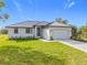 Charming single-story home with well-manicured lawn, grey metal roof and paver driveway at 16760 Acapulco Rd, Punta Gorda, FL 33955