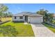 Charming single-story home with well-manicured lawn, grey metal roof and paver driveway at 16760 Acapulco Rd, Punta Gorda, FL 33955
