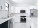 Modern kitchen with white cabinets, stainless steel appliances and white marble countertops at 16760 Acapulco Rd, Punta Gorda, FL 33955