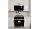 Modern kitchen with white cabinets, stainless steel appliances and white marble countertops with black hardware at 16760 Acapulco Rd, Punta Gorda, FL 33955