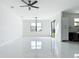Bright living room features modern light fixture, ceiling fan, and large windows at 16760 Acapulco Rd, Punta Gorda, FL 33955