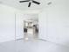 Bright living room with modern ceiling fan and white double doors leading to the kitchen at 16760 Acapulco Rd, Punta Gorda, FL 33955