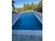 A pristine rectangular pool features a tiled edge and modern paving, surrounded by a secure, stylish black fence at 16760 Acapulco Rd, Punta Gorda, FL 33955