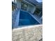 An inviting in-ground pool showcases clean lines and sophisticated tile work, complemented by elegant stone paving at 16760 Acapulco Rd, Punta Gorda, FL 33955