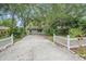 Front view of a house with a long driveway and white picket fence at 4135 Bell Ave, Sarasota, FL 34231