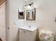 Bathroom with white vanity, double mirrors, and neutral decor at 7319 Lagoon Rd, Spring Hill, FL 34606