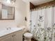 Bathroom with shower/tub, floral curtain, and white vanity at 7319 Lagoon Rd, Spring Hill, FL 34606