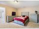 Bedroom with gray dresser, bed, and TV at 7319 Lagoon Rd, Spring Hill, FL 34606
