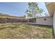 Large backyard with screened patio and wooden fence at 4404 Terry Loop, New Port Richey, FL 34652