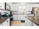 Modern kitchen featuring white cabinets, granite countertops, and stainless steel appliances at 12211 Streambed Dr, Riverview, FL 33579
