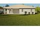 Spacious backyard with grassy area and covered patio at 49 Mark Twain Ln, Rotonda West, FL 33947