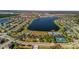 Overhead view of a Primary-planned community surrounding a large lake, pool, tennis court, and recreation center at 1570 Fox Grape Loop, Lutz, FL 33558