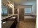 Elegant bathroom with a double sink vanity, glass-enclosed shower, and soaking tub at 1570 Fox Grape Loop, Lutz, FL 33558